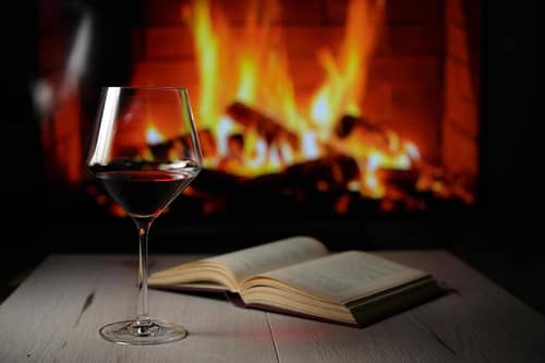 4184124-bicchiere-di-vino-rosso-secco-libro-aperto-e-camino-gratuito-foto